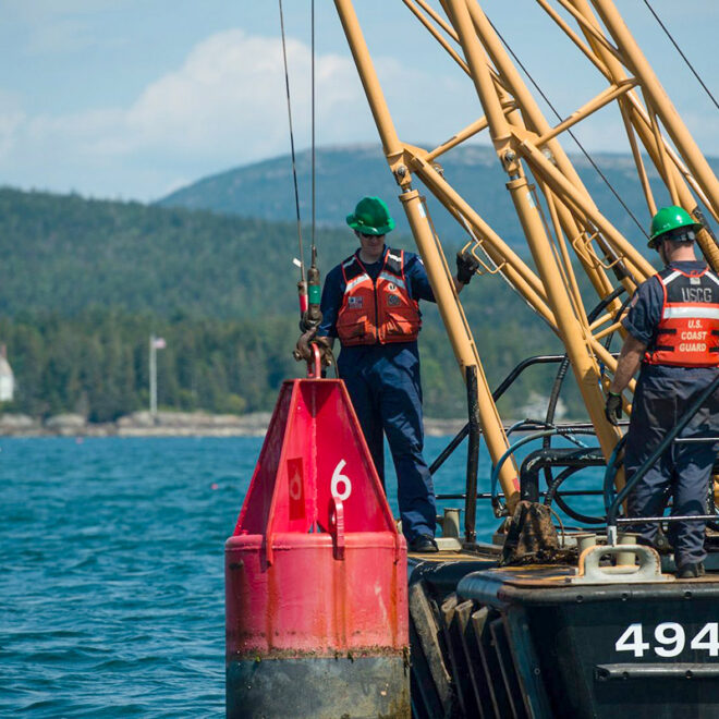 US Coast Guard crew hauling a navigation marker for inspection and maintenance