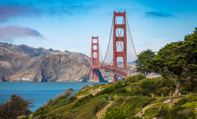 The Golden Gate Bridge surrounded by lush greenery and the calm waters of the San Francisco Bay