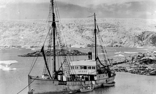 A black and white photo of Sir Ernest Shackleton's ship, Quest, with a glacier in the background