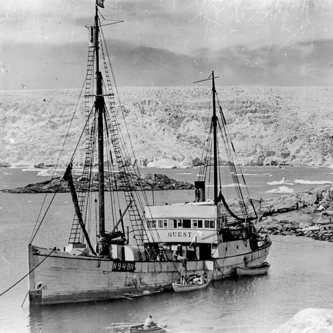 A black and white photo of Sir Ernest Shackleton's ship, Quest, with a glacier in the background