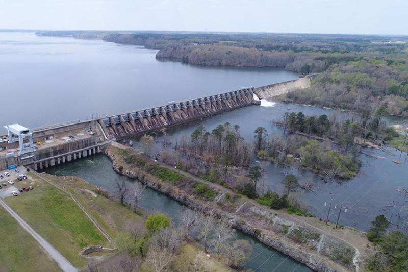 Roanoke Rapids Dam on the Roanoke River in North Carolina. The powerhouse and spillway are to the left, the bypassed reach of the river is on the right. On the right side of the dam, water is flowing over the spillway and into the bypassed reach. Credit: Dominion Energy.