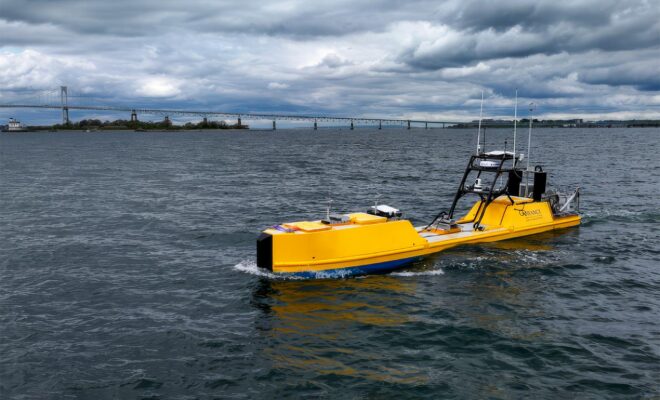 NOAA Autonomous Surface Vehicle in Narragansett Bay during testing. Goat Island and the Newport Bridge in the background.
