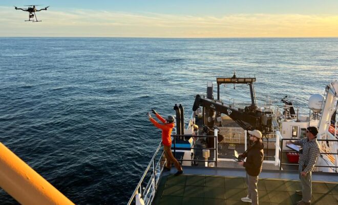Rhyl Frith prepares to catch the FreeFly Astro research drone on the R/V Nancy Foster while tagging whales. Taken under NOAA permit # 27066. Credit: Julia Zeh